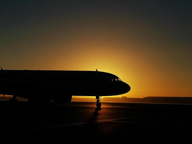 An Airbus A350 taking off at sunset, emphasizing its wide body and the curved wingtips. The lighting highlights the aircraft's sleek design and the sense of long-distance travel.