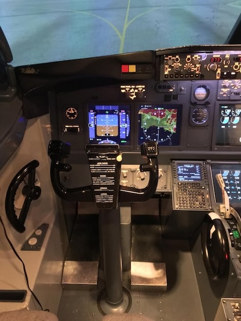 An interior shot of a modern aircraft cockpit, showcasing the advanced avionics and navigation systems used to optimize flight paths and fuel efficiency.