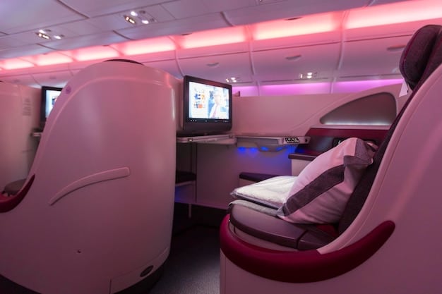 A modern airplane cabin with comfortable seating, individual entertainment screens displaying movies, and ambient lighting, illustrating the enhanced passenger experience due to technological advancements.
