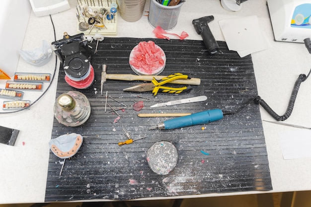 Pinstriping tool kit with assorted brushes, paints, and masking tape neatly arranged on a workbench. The variety of brush sizes and paint colors suggests the wide range of design options available to the pinstriping artist. The organization of the tools reflects the precision and attention to detail required in the craft.
