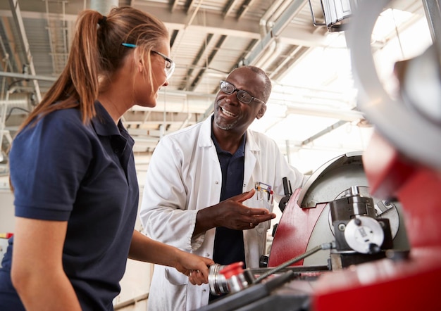 Members of a car club collaborating on a restoration project on a classic car in a well-equipped garage, showing teamwork and shared expertise.