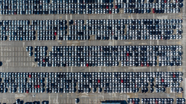 Aerial view of a bustling drive-in movie theater. Cars are neatly arranged in rows, facing the large screen. The concessions stand is visible, with people lining up to purchase snacks. The image captures the lively atmosphere and the sense of community at the drive-in.