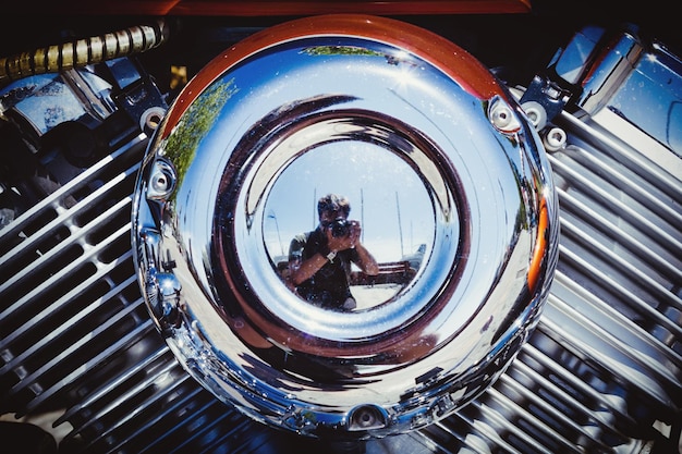 A close-up shot of a highly customized hot rod engine at a car show, showcasing intricate chrome detailing, polished components, and a powerful supercharger.