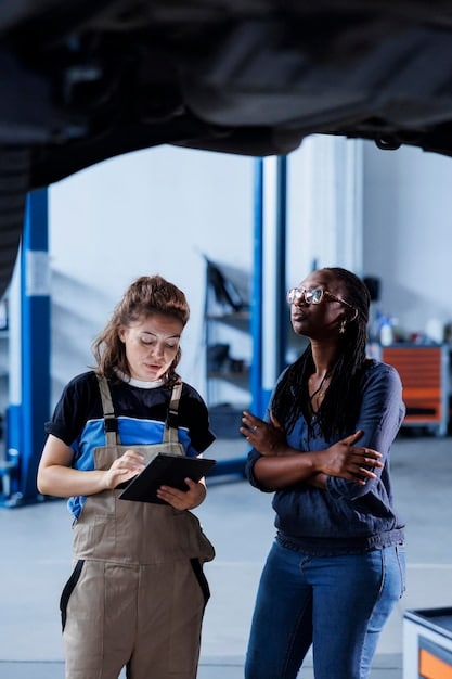 A group of students participating in a hands-on workshop at an automotive museum, learning about the mechanics of a car engine under the guidance of an instructor.