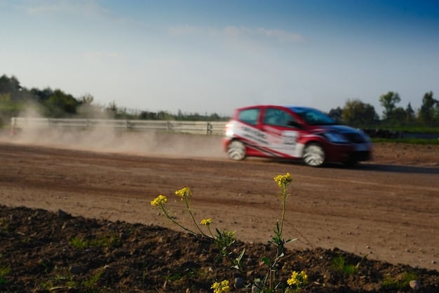 A rally car drifting around a tight corner on a gravel road, kicking up dust and showcasing the driver's skill and control.