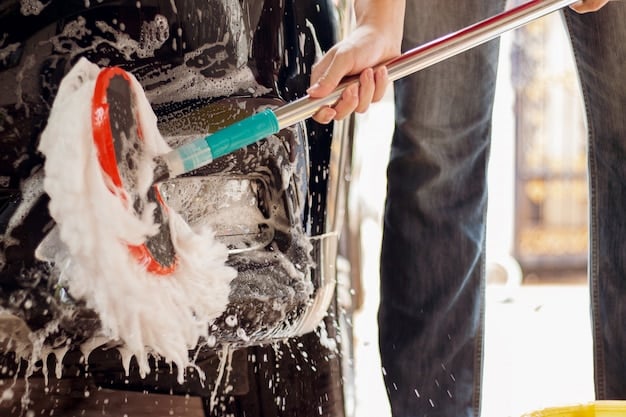 A car being washed with the two-bucket method, showing one bucket with soapy water and another with clean water. The person washing the car is using a microfiber wash mitt.