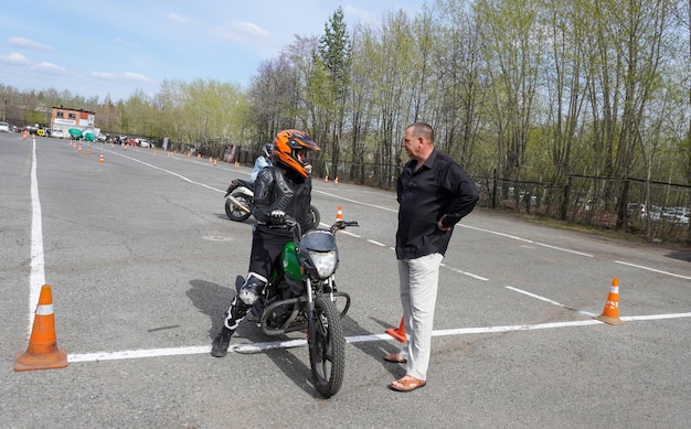 A rider wearing appropriate safety gear is skillfully maneuvering a Honda Grom through a series of tight turns on a closed course, demonstrating its agile handling and responsiveness.
