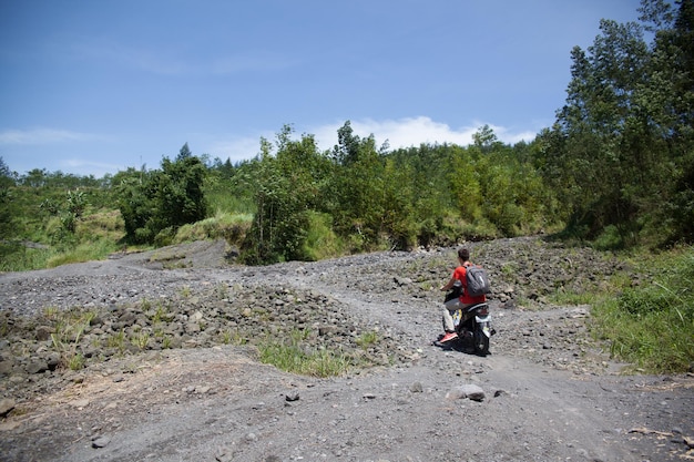 The Kawasaki Versys-X 300 navigating a gravel road, demonstrating its ability to handle unpaved surfaces with stability and control. Rider is wearing appropriate safety gear.