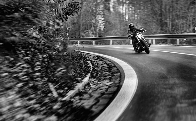 A Kawasaki Z900 2025 inclinada em uma curva fechada, com o asfalto visível sob os pneus. A imagem deve enfatizar a estabilidade e a precisão da moto em curvas.