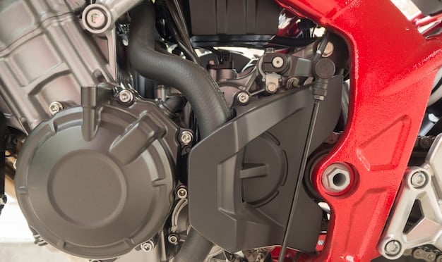 Close-up of the 2024 Honda CBR650R's inline four-cylinder engine, highlighting its compact design and the Honda logo on the engine case. The lighting should emphasize the metallic finish and the overall cleanliness of the engine.