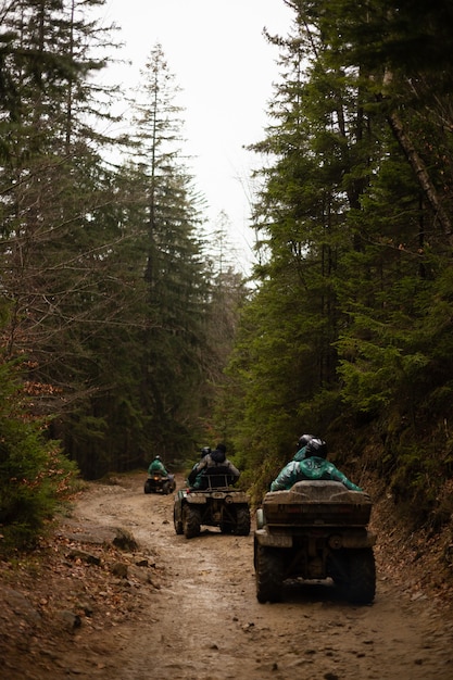The CFMOTO Ibex 800 T navigating a rocky, uneven trail, showcasing its long-travel suspension and high ground clearance. The rider is standing up on the pegs, demonstrating proper off-road riding technique. The background features a dense forest, reinforcing the bike's adventurous capabilities.