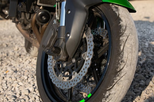Close-up of the 2024 Kawasaki Ninja 400's front suspension and brake caliper. The photo is sharply focused on these components, showcasing their design and engineering. The background is slightly blurred to emphasize the foreground details.